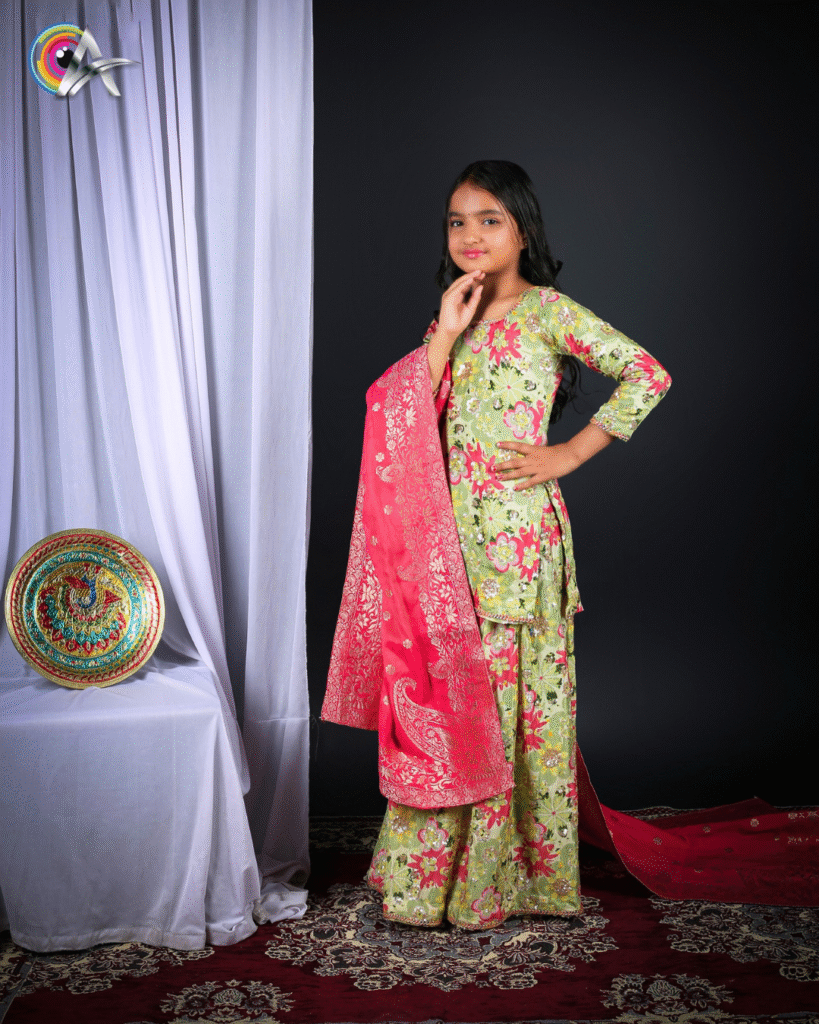 Young girl wearing a lehenga-style dress with floral prints and a red embroidered dupatta.