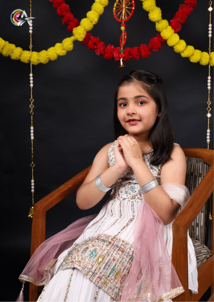 "Little girl in a beautiful white embroidered suit posing elegantly for a fashion photoshoot."